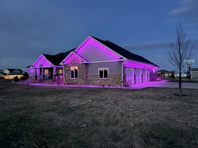 Large single-story house with bright magenta and purple exterior lighting at dusk against a blue twilight sky